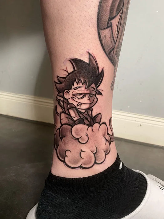 Small Blackwork Goku on Cloud Cartoon Tattoo on Men Ankle by @christof_groll