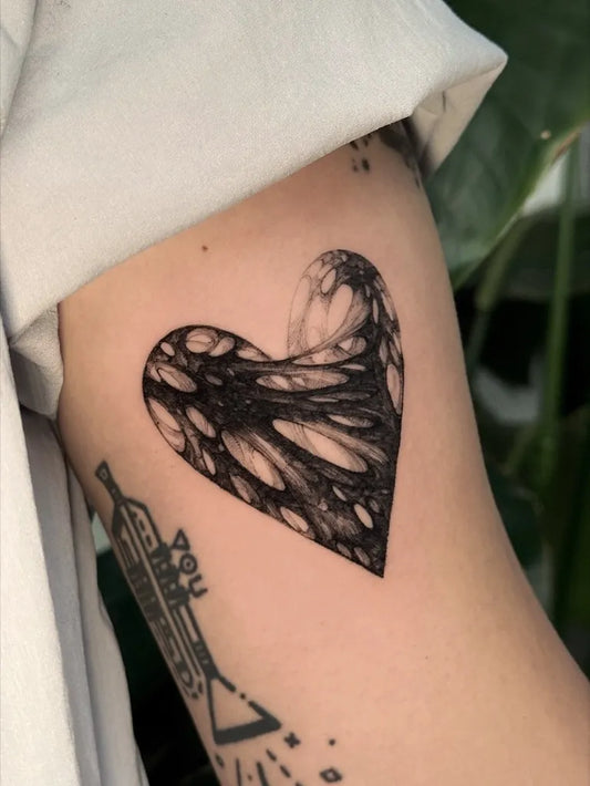 Small Blackwork Heart on Women Arm Tattoo by @hynngloomy.tattoo