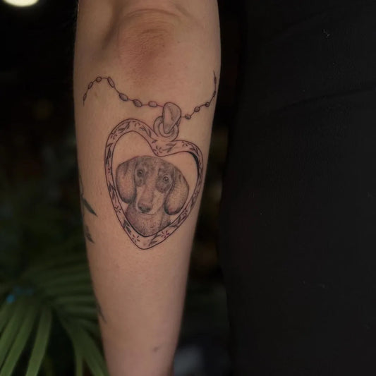 Small Blackwork Heart with Dachshund on Women Arm Tattoo by @big.bird.tattoo