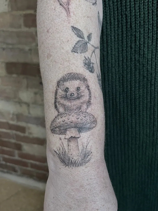 Small Blackwork Hedgehog Mushroom Nature Tattoo on Women Arm by @jochastney.tattoo