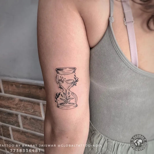 Small Blackwork Hourglass with Flowers Tattoo on Women Arm by @globaltattooindia