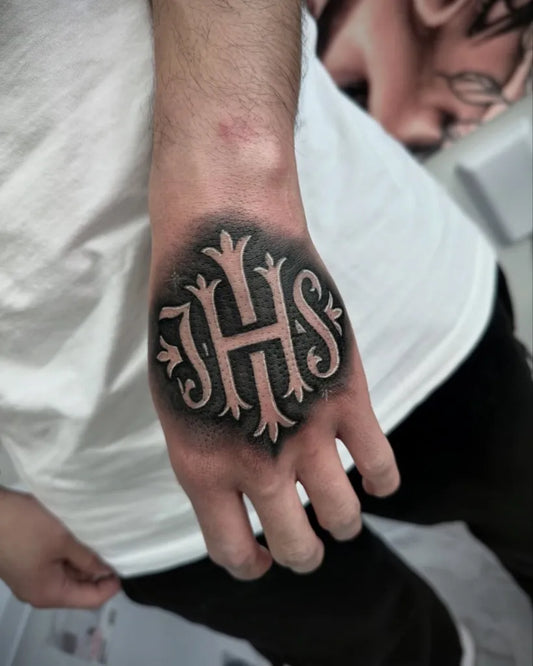 Small Blackwork IHS Monogram on Men Hand Tattoo by @alartink