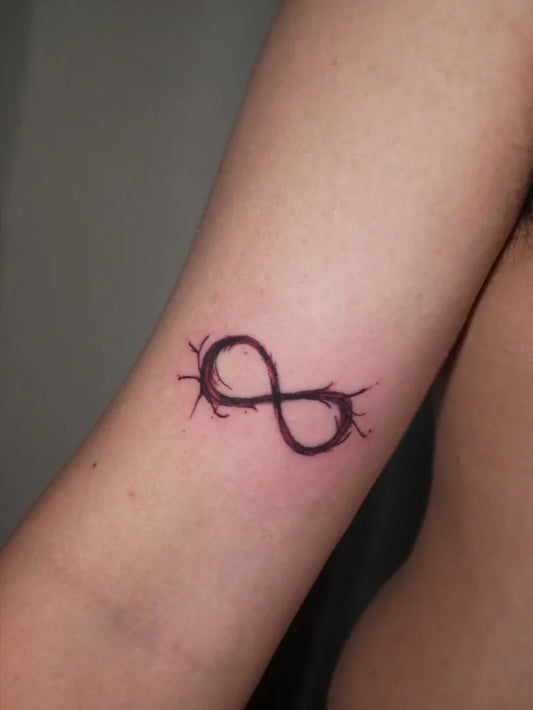 Small Blackwork Infinity with Barbed Wire Tattoo on Women Forearm by @tattoosbybink