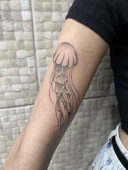 Small Blackwork Jellyfish Tattoo on Women Arm by @nanda_ramona_tattoo_sunset