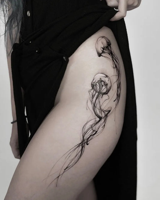 Small Blackwork Jellyfish Tattoo on Women Thigh by @ani.cinski.tattoo