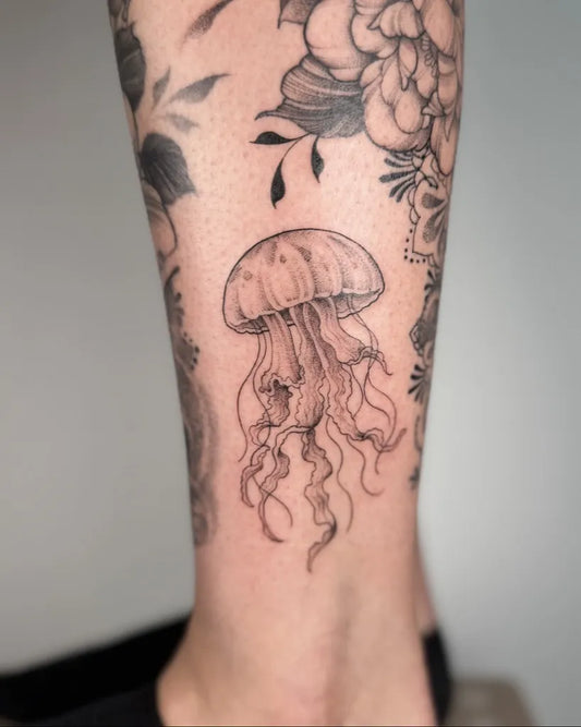 Small Blackwork Jellyfish and Flowers Tattoo on Women Leg by @meganbirdtattoo