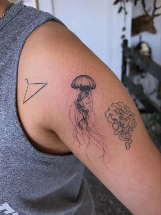 Small Blackwork Jellyfish and Hanger Tattoo on Women Arm by @trinity.tatt
