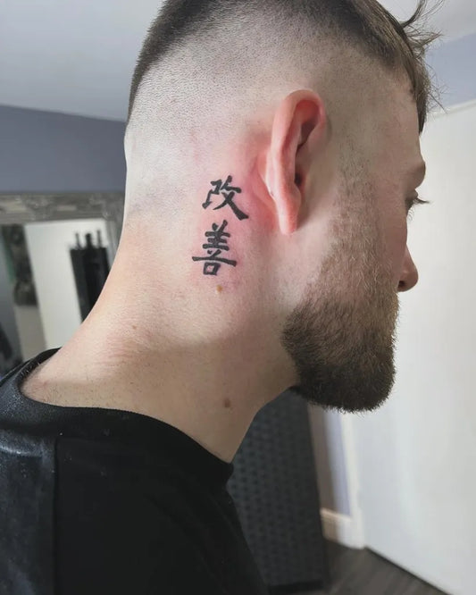 Small Blackwork Kaizen Kanji Tattoo on Men Behind the Ear by @tabby.tattoos