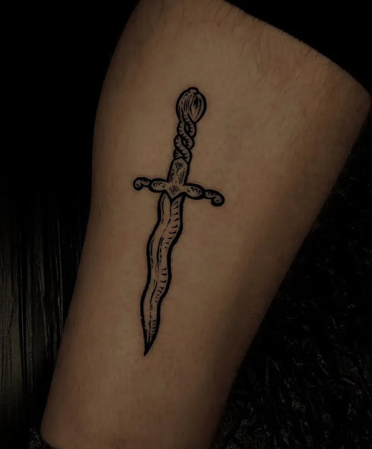Small Blackwork Knife Tattoo on Men Leg by @jot.ka.ell.tattoo