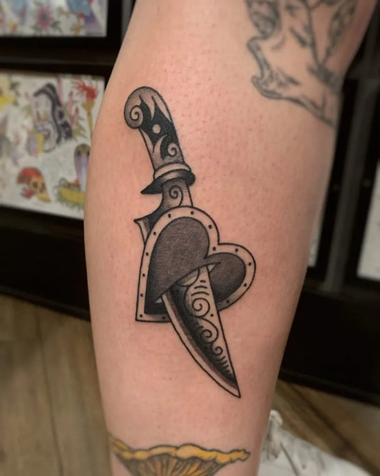 Small Blackwork Knife and Heart Tattoo on Women Leg by @tegatattoo