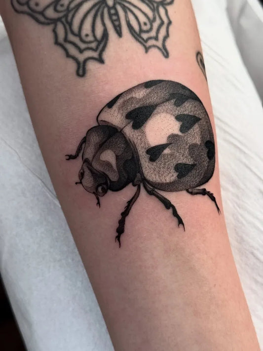 Small Blackwork Ladybug Tattoo on Women Arm by @inkyyourboi