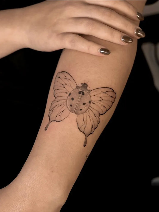 Small Blackwork Ladybug Tattoo on Women Forearm by @inked_by_katerina