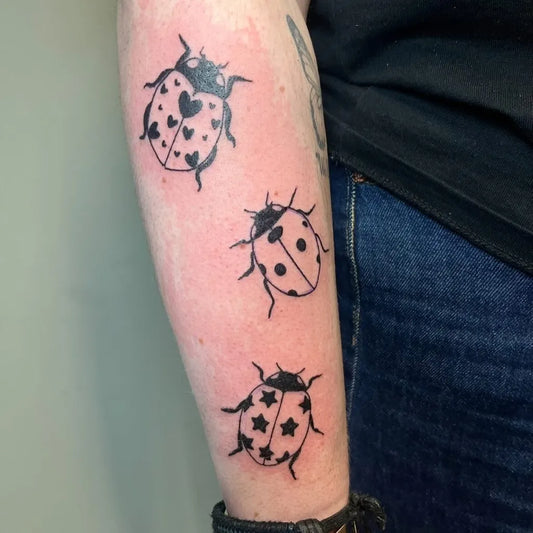 Small Blackwork Ladybugs Tattoo on Women Arm by @inkedbyelain