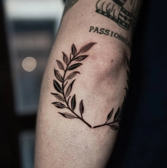 Small Blackwork Laurel Wreath Tattoo on Men Arm by @ahrip.k_ttt
