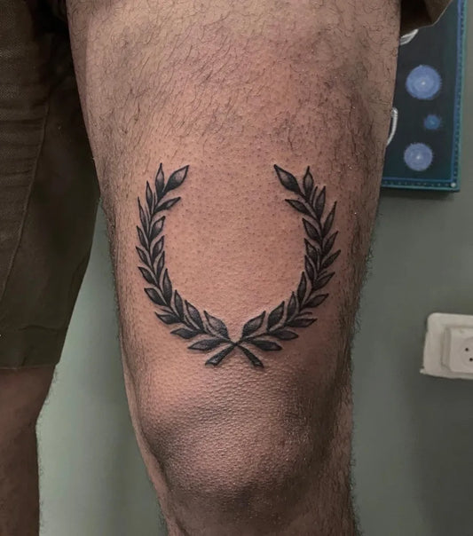 Small Blackwork Laurel Wreath Tattoo on Men Knee by @koolkat.ww