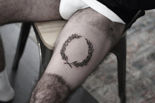 Small Blackwork Laurel Wreath Tattoo on Men Thigh by @ashtattz