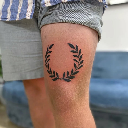 Small Blackwork Laurel Wreath Tattoo on Men Thigh by @danielaseccia