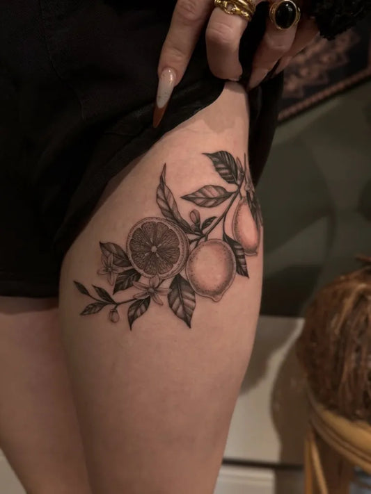 Small Blackwork Lemon Branch on Women Thigh Tattoo by @deadbeat__steve