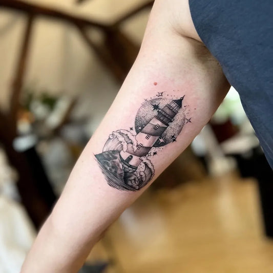 Small Blackwork Lighthouse and Ship Tattoo on Women Arm by @nameless.skopje