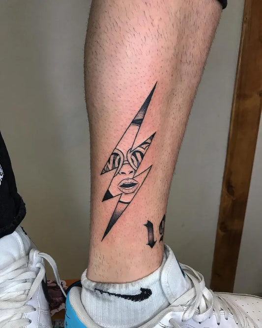 Small Blackwork Lightning Bolt with Mask Tattoo on Men Leg by @mrs.pame.ink.tattoo