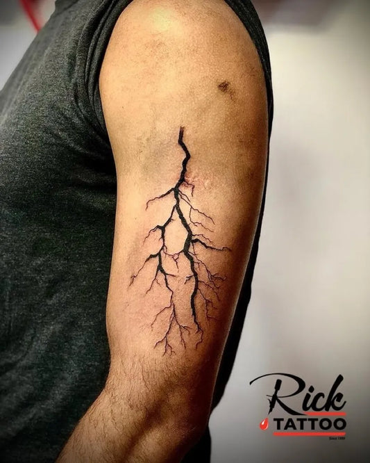 Small Blackwork Lightning Tattoo on Men Arm by @ricktattoostudiomauritius