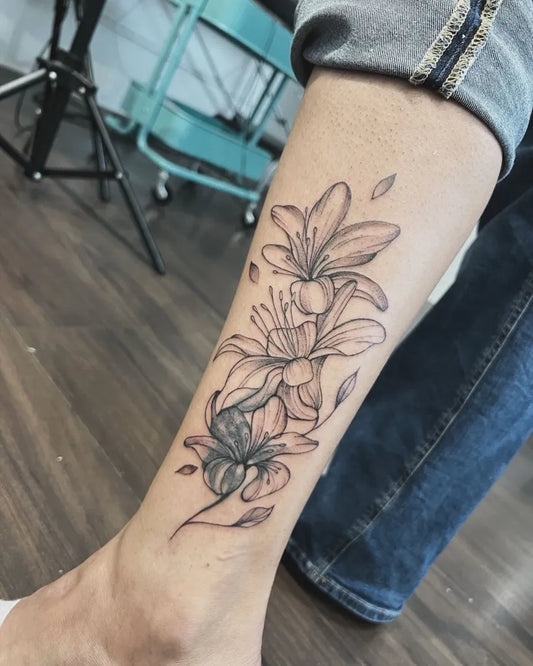Small Blackwork Lily Flowers on Women Leg Flower Tattoo by @valentina.pezzoli_emilys_ink