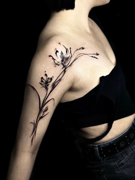 Small Blackwork Lily branch on Women Shoulder Flower Tattoo by @danya__tattoo
