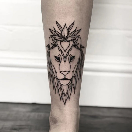 Small Blackwork Lion with Crown and Flowers on Women Leg Tattoo by @ashleesnowtattoo