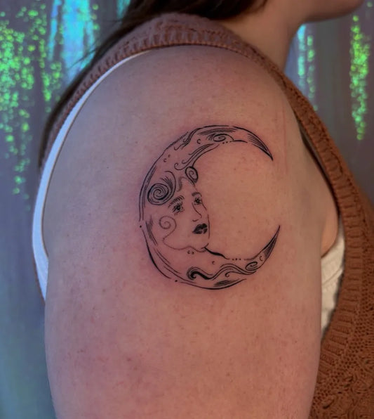 Small Blackwork Moon Face Tattoo on Women Shoulder by @laurcar_bodyart