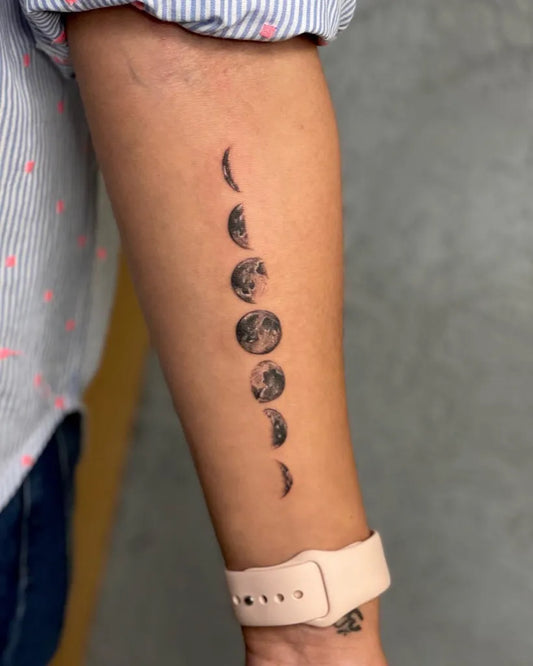 Small Blackwork Moon Phases Tattoo on Women Arm by @temptink_tattoo_delhi