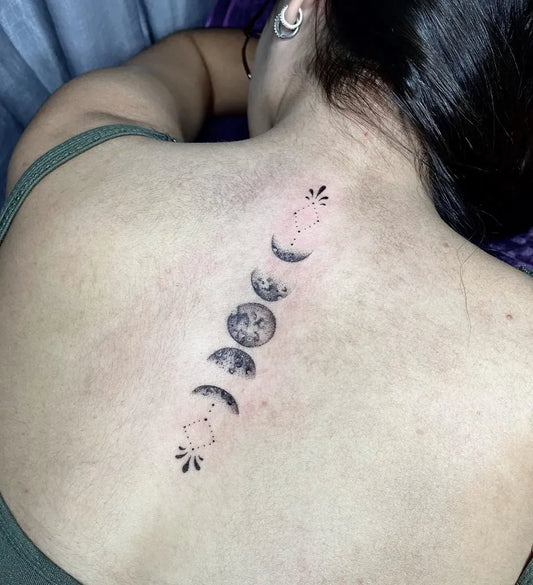 Small Blackwork Moon Phases Tattoo on Women Back by @lorrainy.tatts