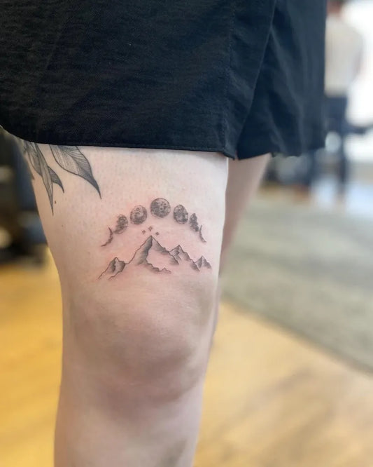 Small Blackwork Moon Phases and Mountains Tattoo on Women Thigh by @amberbreeze.tattoo