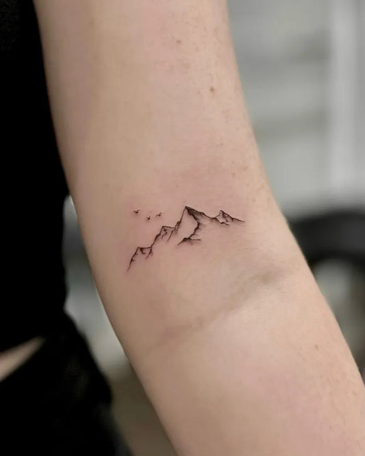 Small Blackwork Mountain Tattoo on Women Arm by @a.ink.tattoo_ellie