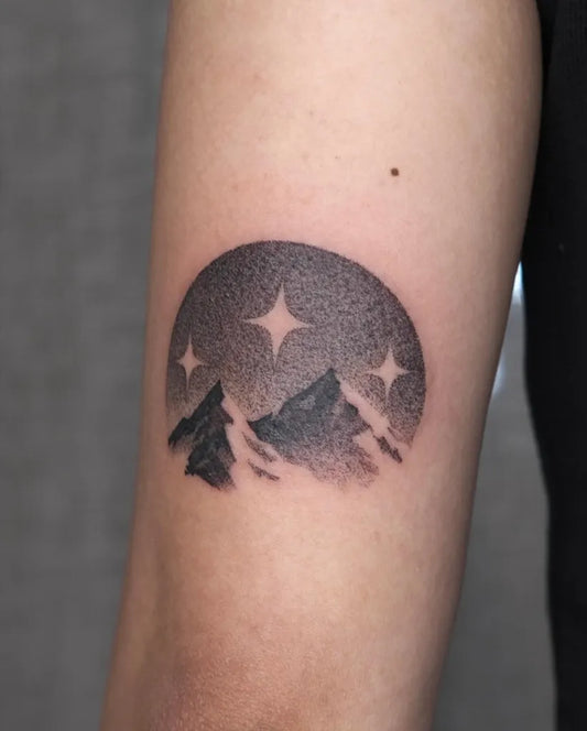 Small Blackwork Mountain and Stars Tattoo on Women Arm by @citruslucy.ink