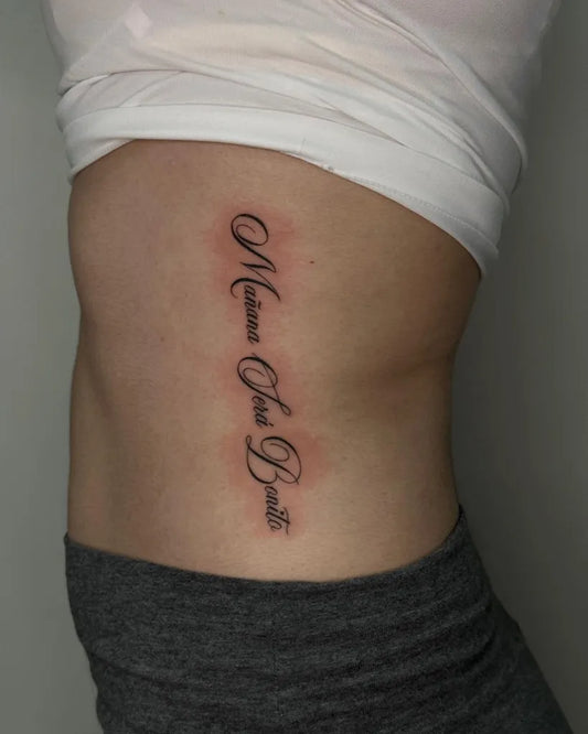 Small Blackwork Name Tattoo on Women Rib by @baby.kait