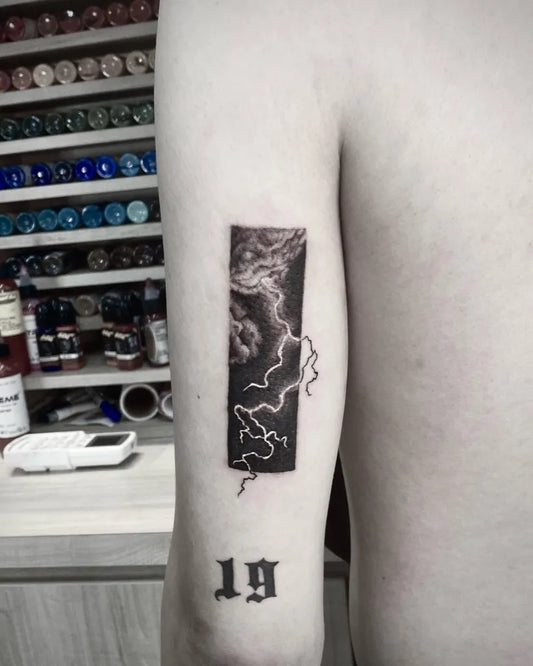 Small Blackwork Negative Space Lightning Bolt Tattoo on Men Arm by @alison_tattooist