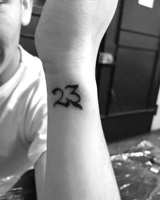 Small Blackwork Number 23 Tattoo on Men Wrist by @gi_tattoos