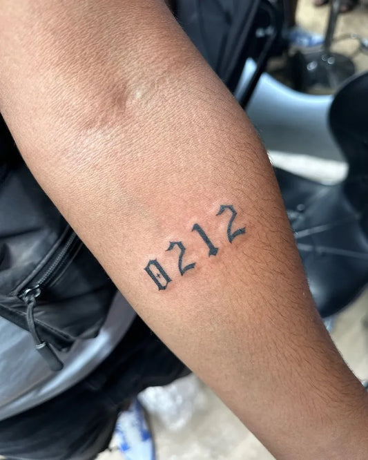 Small Blackwork Numbers Tattoo on Men Arm by @tatouage_marrakech