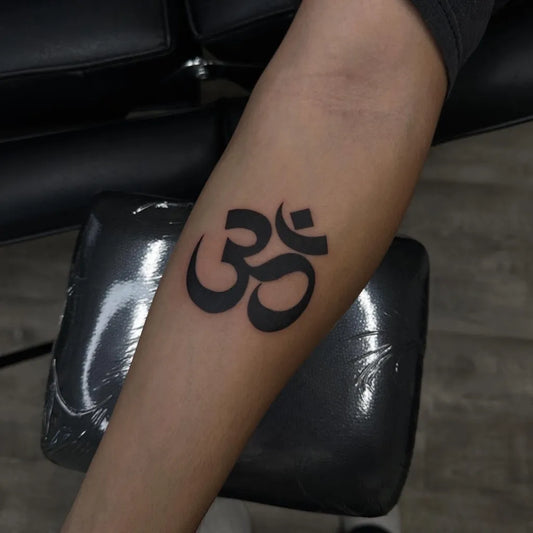 Small Blackwork Om Symbol Spiritual Tattoo on Women Forearm by @serendripitystudios