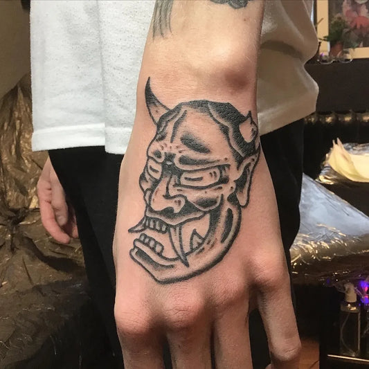 Small Blackwork Oni Mask on Men Hand Tattoo by @kuraditosin13
