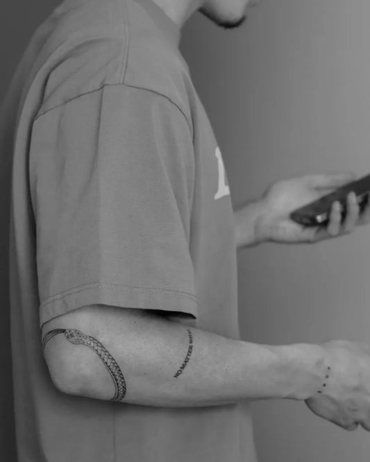 Small Blackwork Ouroboros Tattoo on Men Elbow by @tattooboutiquelarissa