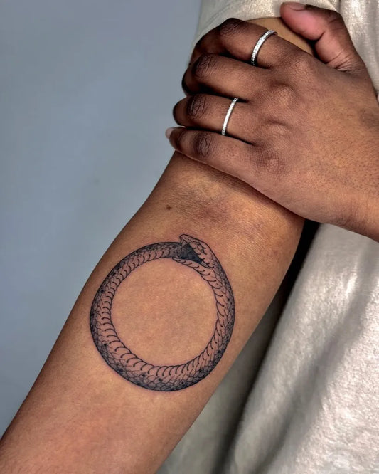 Small Blackwork Ouroboros Tattoo on Women Arm by @inkedbychau