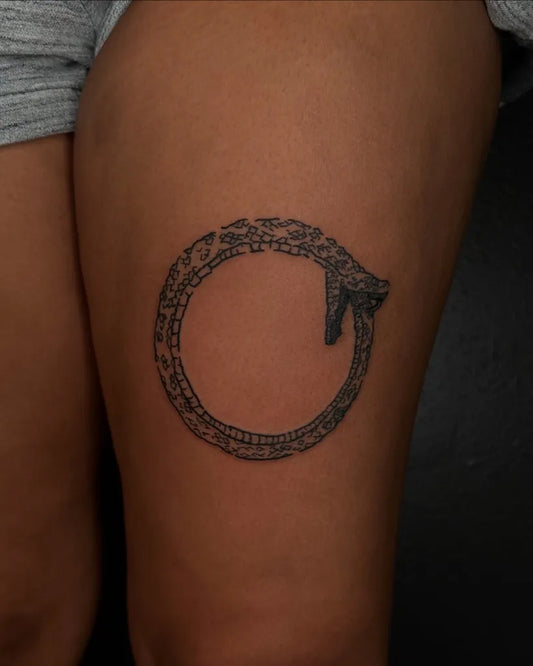 Small Blackwork Ouroboros Tattoo on Women Thigh by @tapiotats