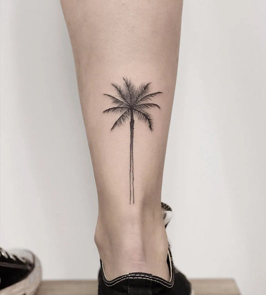 Small Blackwork Palm Tree Tattoo on Women Leg by @naor__aviv