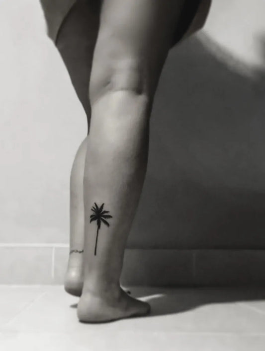 Small Blackwork Palm Tree Tattoo on Women Leg by @that.dubai.mama