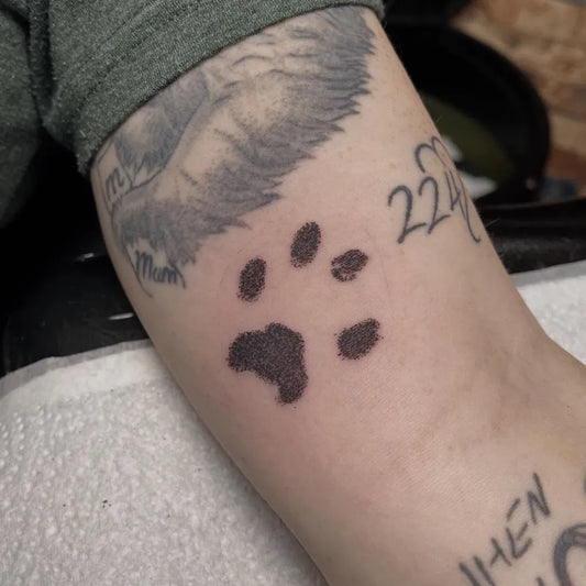 Small Blackwork Paw Print Tattoo on Men Arm by @kay_b_adelman_tattoos