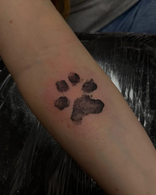 Small Blackwork Paw Print Tattoo on Women Arm by @distinktiontattoostudio_rugby