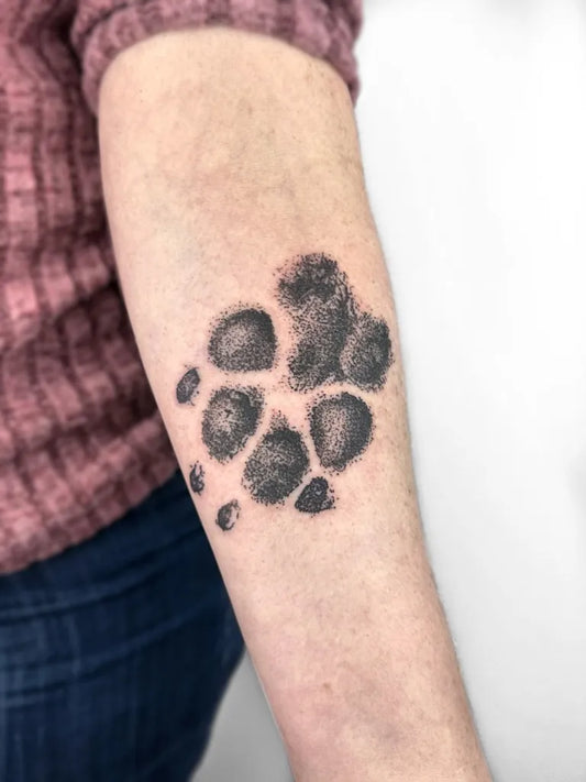Small Blackwork Paw Print Tattoo on Women Arm by @mercyraintattoos