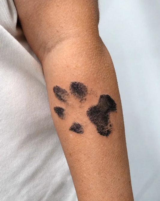 Small Blackwork Paw Print Tattoo on Women Arm by @tattooist_kimria