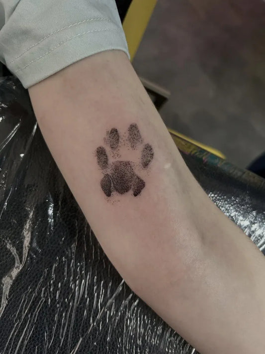 Small Blackwork Paw Print Tattoo on Women Arm by @termite_tattoo